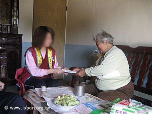 阿嬤收下關懷金，感恩    導師的照顧。