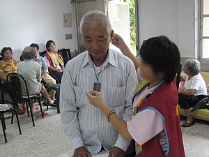 為阿公掛上噶居寺的平安袋，祝阿公健康長壽。